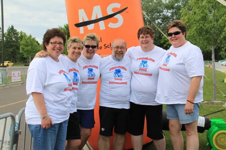 Early team members at an MS event arch